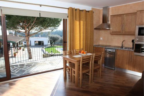 a kitchen with a table with chairs and a balcony at Casa de Santo Antonio in Mortágua
