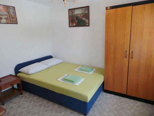 a small bedroom with a bed and a cabinet at Apartment Karlobag/Velebit Riviera 27804 in Karlobag
