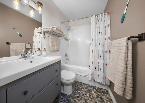 a bathroom with a sink and a toilet and a shower at Mountain Gate - Pet Friendly 2BR w Mountain Views and open hot tub in Canmore