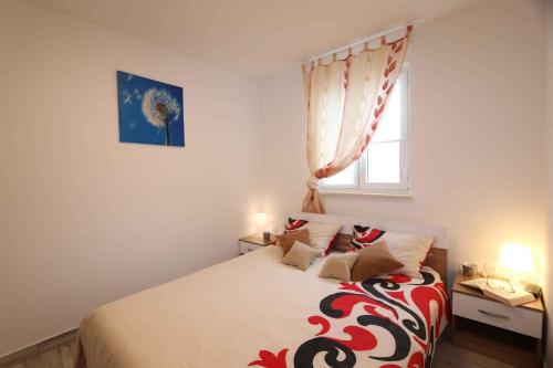 a bedroom with a bed with a red and white blanket at Apartments in Silo/Insel Krk 26753 in Šilo