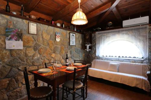 Dobrinj的住宿－Holiday home in Dobrinj/Insel Krk 27652，一间设有桌子和石墙的用餐室