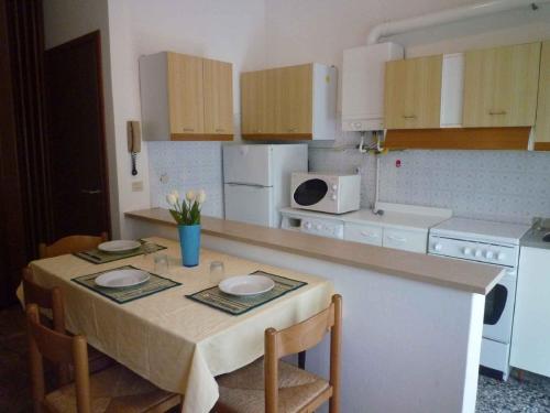 uma cozinha com uma mesa com dois pratos em Apartments in Eraclea Mare 25693 em Eraclea Mare