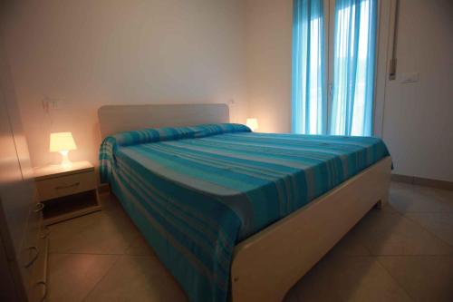 1 dormitorio con 1 cama con edredón azul en Apartments in Rosolina Mare 25008, en Rosolina Mare