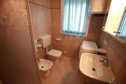 Baño pequeño con aseo y lavamanos en Apartments in Rosolina Mare 25008, en Rosolina Mare