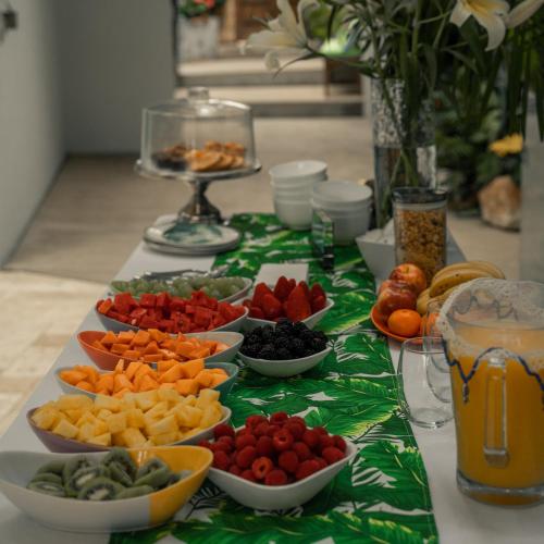 a table topped with bowls of different fruits and vegetables at Anjali Casa Divina in Sayulita