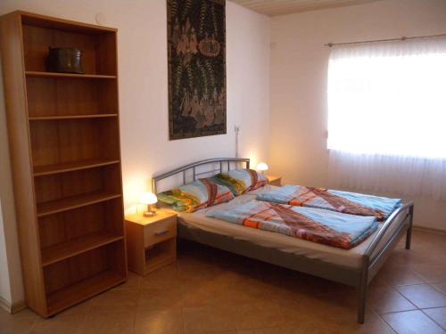 a bedroom with a bed and a book shelf at Holiday home in Balatonszentgyörgy 20188 in Balatonszentgyörgy