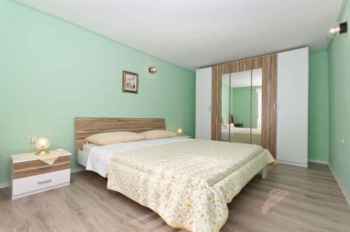 a bedroom with a large bed and a mirror at Holiday home in Lopar/Insel Rab 17776 in Lopar