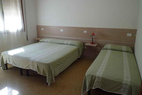 Zimmer mit 2 Betten und einem Fenster in der Unterkunft Apartments in Eraclea Mare 25611 in Eraclea Mare