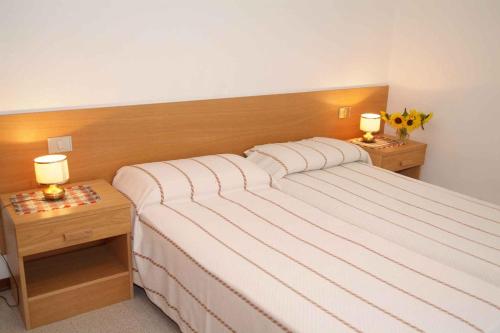 a bedroom with a large bed with two night stands at Apartments in Pieve di Ledro/Ledrosee 22632 in Ledro