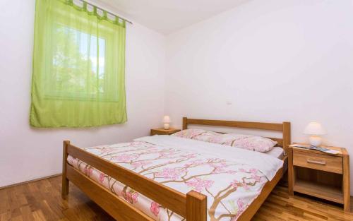 a bedroom with a bed and a window with green curtains at Apartment in Silo/Insel Krk 13580 in Šilo
