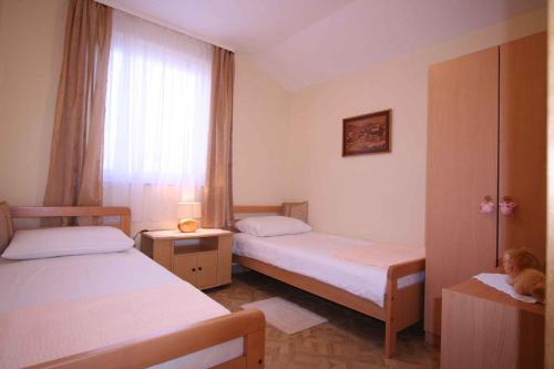 a small room with two beds and a window at Apartments in Silo/Insel Krk 13442 in Šilo