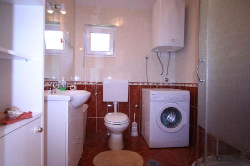 a bathroom with a toilet and a washing machine at Apartments in Silo/Insel Krk 13442 in Šilo
