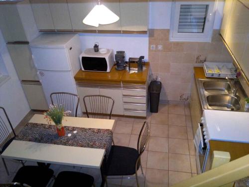 a small kitchen with a table and a microwave at Apartment in Njivice/Insel Krk 13324 in Njivice