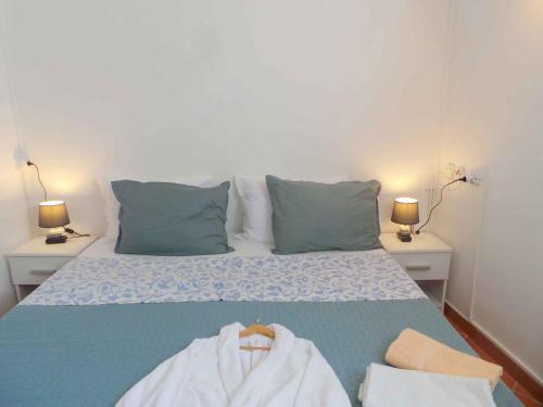 Cama con sábanas y almohadas azules y blancas en One-Bedroom Holiday home in Umag - Istrien 12158, en Umag