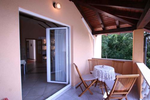 una casa con balcón con mesa y sillas en Apartments in Silo - Insel Krk 13442, en Šilo