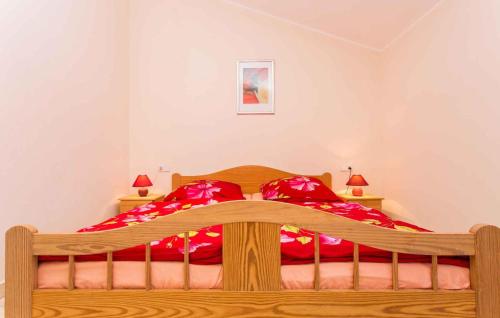 Apartment in Silo/Insel Krk 13488 في سيلو: غرفة نوم بسرير خشبي مع شراشف حمراء