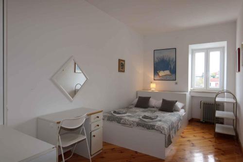 Un dormitorio blanco con una cama y un escritorio. en Holiday home in Silo - Insel Krk 26695, en Šilo