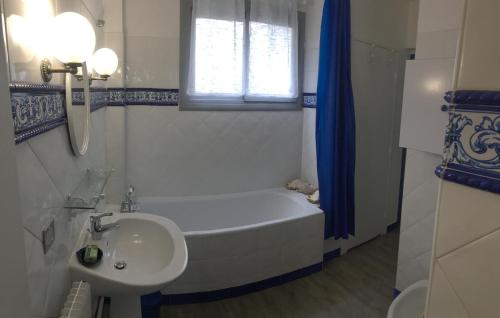 une salle de bain blanche avec une baignoire et un lavabo dans l'établissement Appartement à 300m du centre et des plages, à Collioure