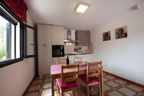 a kitchen with a table and chairs in a room at Two-Bedroom Apartment in Siracusa II in Ognina