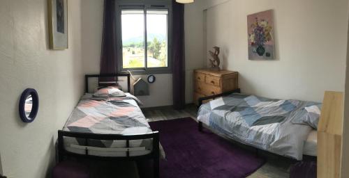 une chambre avec un lit, une commode et une fenêtre dans l'établissement Appartement à 300m du centre et des plages, à Collioure