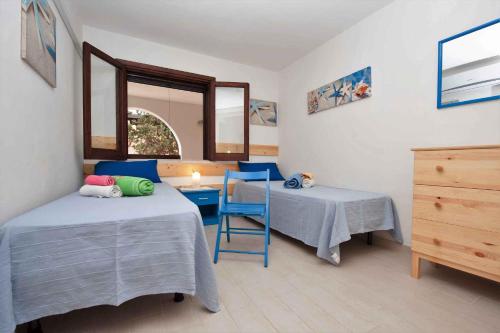 a room with two beds and a table and a window at Two-Bedroom Apartment in Siracusa I in Ognina