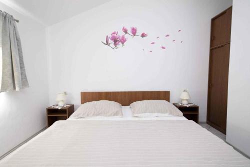 a bedroom with a bed with flowers on the wall at Apartment Crikvenica 16 in Crikvenica