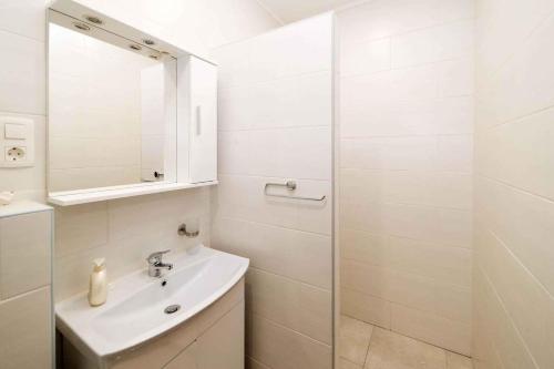 a white bathroom with a sink and a shower at Apartment Crikvenica 16 in Crikvenica