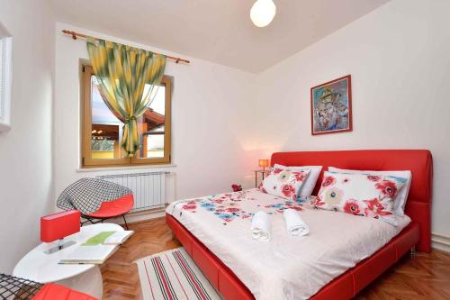 ein Schlafzimmer mit einem roten Bett und einem roten Stuhl in der Unterkunft Holiday home Poljana - Insel Ugljan 7467 in Poljana