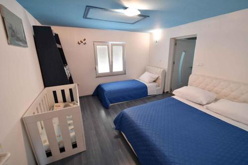 Habitación pequeña con 2 camas y cuna en Holiday home Hrvace/Split Riviera 7302, en Markulin