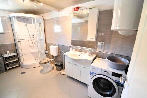 y baño con lavabo y lavadora. en Holiday home Hrvace/Split Riviera 7302, en Markulin