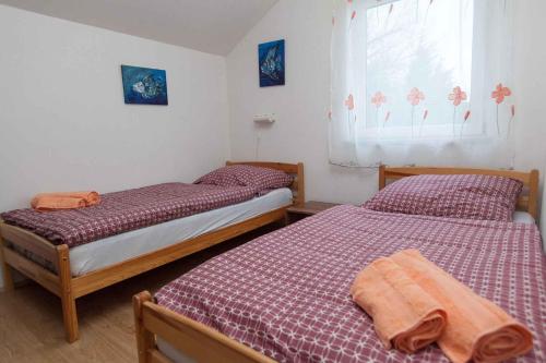 2 łóżka pojedyncze w sypialni z oknem w obiekcie Three-Bedroom Apartment in Crikvenica IV w mieście Klanfari