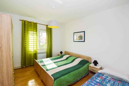 ein Schlafzimmer mit einem grünen und weißen Bett und einem Fenster in der Unterkunft Apartment in Pula with Two-Bedrooms 3 in Pula