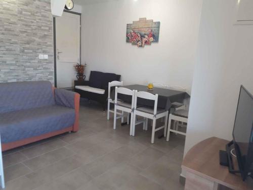 a living room with a couch and a table and chairs at Apartment in Lopar with Two-Bedrooms 2 in Lopar