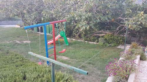a playground in a yard with a swing at Apartment in Lopar/Insel Rab 17757 in Lopar