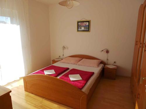 a bedroom with a bed with a red blanket on it at Apartment Valbandon, Istria 11 in Fondole