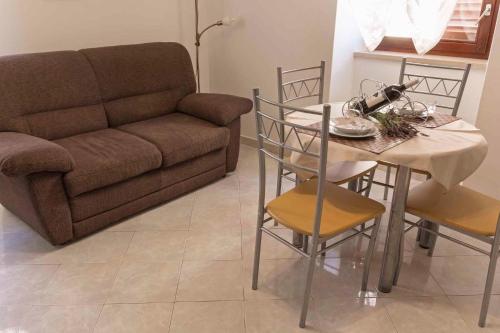 a living room with a couch and a table and chairs at Holiday home in Moscenice 15209 in Mošćenice