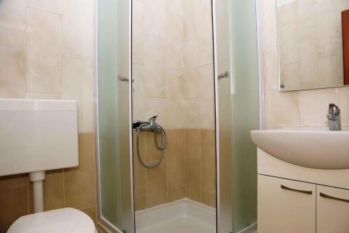 uma casa de banho com um chuveiro, um WC e um lavatório. em Brna, otok Korcula Two-Bedroom Apartment 1 em Brna