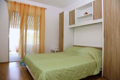 a bedroom with a green bed and a window at Brna, otok Korcula Two-Bedroom Apartment 1 in Brna