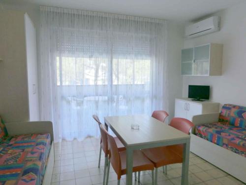 a living room with a table and chairs and a couch at Apartment in Bibione I in Bibione