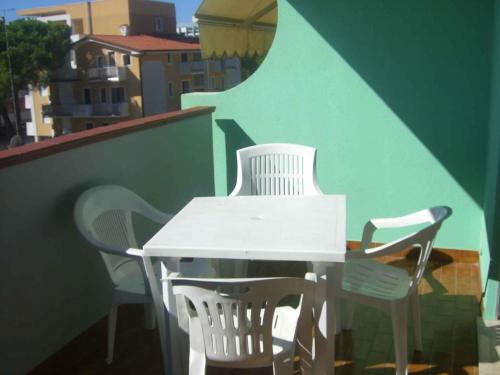 ビビオーネにあるApartment in Bibione Iの白いテーブルと椅子付きのバルコニー