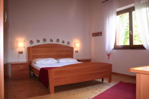 1 dormitorio con cama de madera y ventana en Holiday home in Tiarno di Sotto 23505, en Tiarno di Sotto