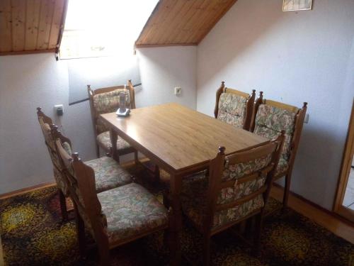 mesa de comedor con sillas y mesa de madera en Two-Bedroom Apartment in Balatonbereny II en Balatonberény