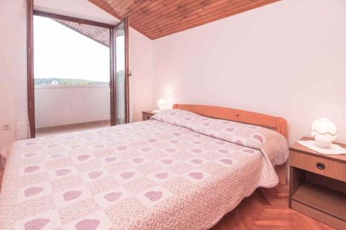 a bedroom with a bed and a large window at Apartments in Mali Losinj 14985C in Mali Lošinj