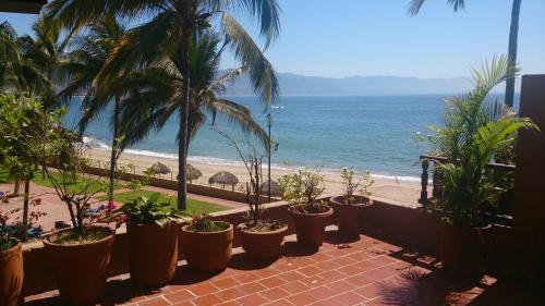 a row of potted plants on a balcony overlooking the beach at Villas del Sol en Los Tules in Puerto Vallarta