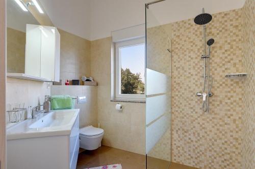 łazienka z prysznicem, umywalką i toaletą w obiekcie Holiday Home Veronika w mieście Vinkuran