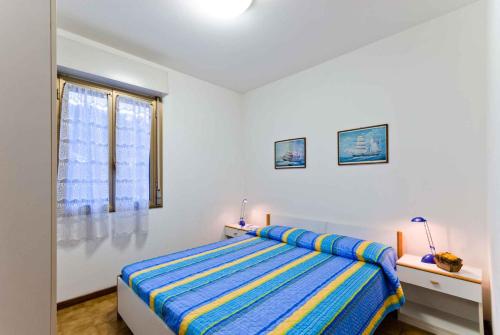 ビビオーネにあるApartment in Bibione 24441の白いベッドルーム(ベッド1台、窓付)