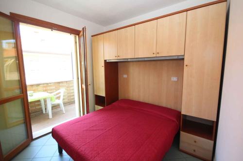 a bedroom with a large red bed in a room at Apartments in Rosolina Mare 24858 in Rosapineta