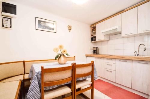 a kitchen with a table with chairs and a sink at Holiday home in Pomer/Istrien 9026 in Pomer
