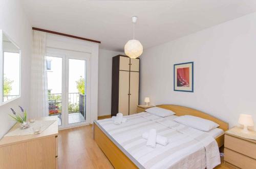 biała sypialnia z dużym łóżkiem i oknem w obiekcie Apartment in Stari Grad/Insel Hvar 6321 w mieście Stari Grad