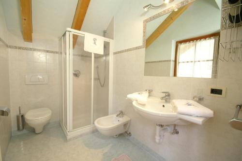 a bathroom with two sinks and a shower and a toilet at Agriturismo La Flu in San Martino in Badia